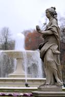 female sculpture in front of a fountain in Warsaw