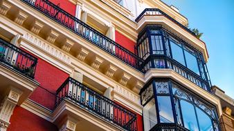 red building facade and black lattice balconies in Madrid, Spain