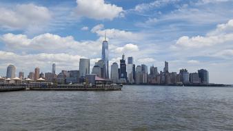 a big city by the water with clouds and sea