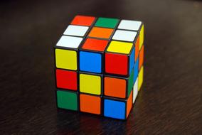 Colorful Rubik's cube with the squares, on the wooden surface