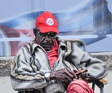 dark skin man sits with Cigar in hand, Cuba