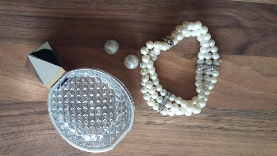 perfume with white beads on the table.