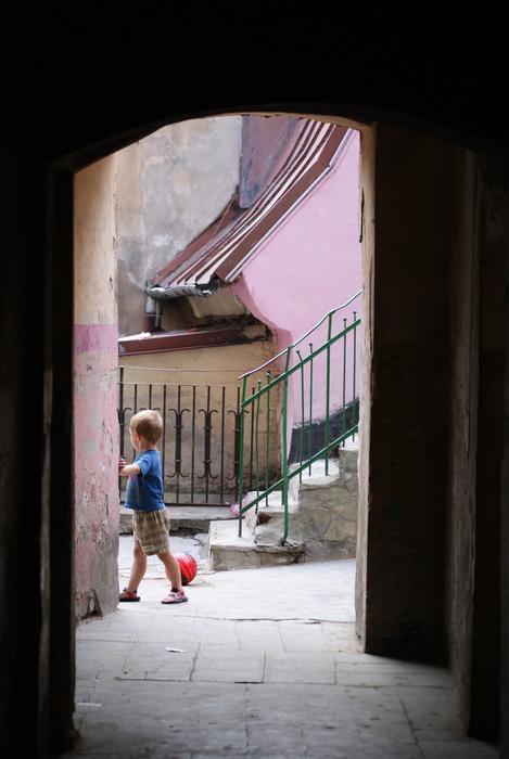 child Boy plays with ball in courtyard, poland, lublin
