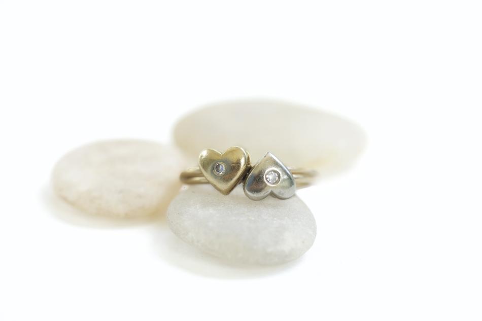 gold rings with hearts on a white pillow