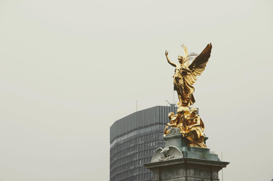 a gold sculpture of an angel in the street