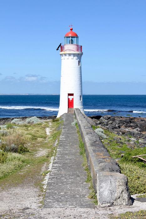 A lighthouse with a road