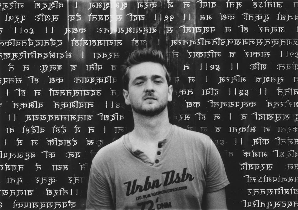 photo of a young man against a background of religious antique scripture