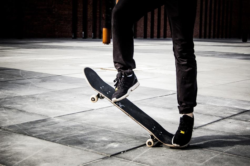 a man in adidas sweatpants rides a skateboard