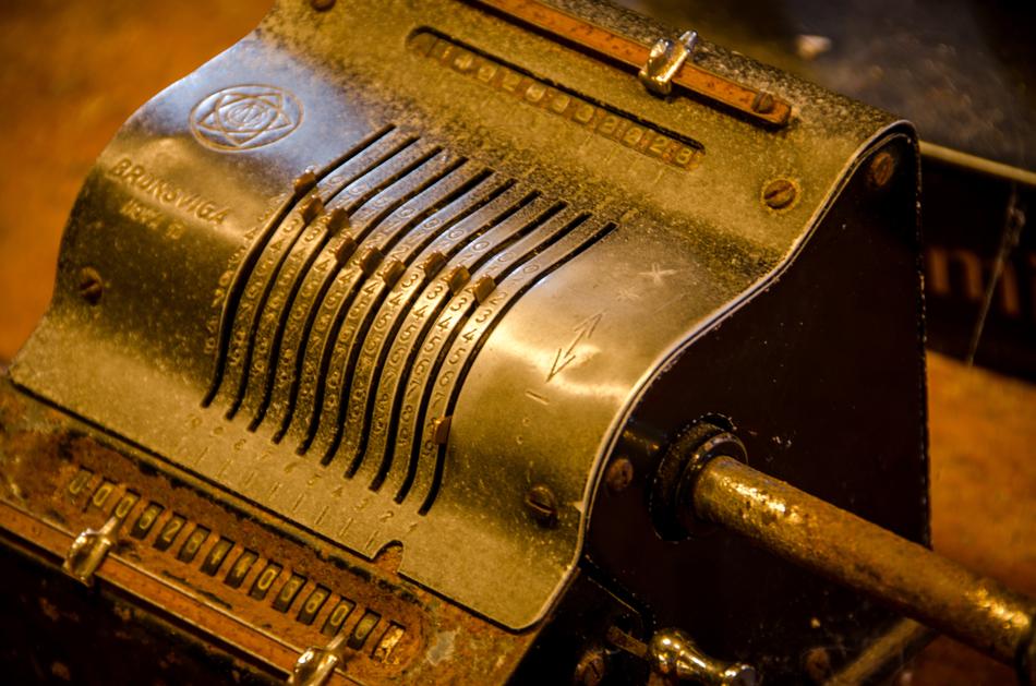 Close-up of the old, antique calculator with signs, in light