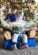 Winter tale, Child boy reading book at christmas tree