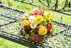 a bunch of flowers on a wet bench