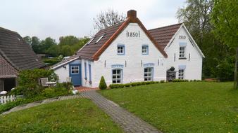 Colorful houses, among the green plants, on the beautiful landscape in East Frisia, Germany