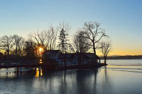 sunset in the trees over the lake in winter