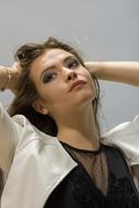model in a black blouse and a white jacket