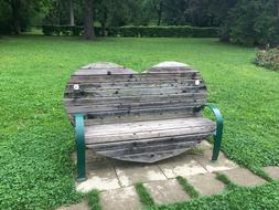 a wooden bench by the grass