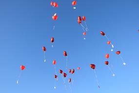 red balloons in a blue sky