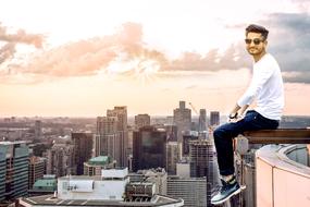 young boy sits above New York city, collage
