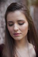 photo of a girl with long hair and downcast eyes
