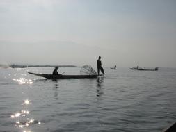 Silhouette of people on a boat clouds