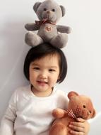 Portrait of the cute child, with the beautiful, colorful and cute Teddy Bears, in China