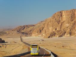 a road in the desert with a bus