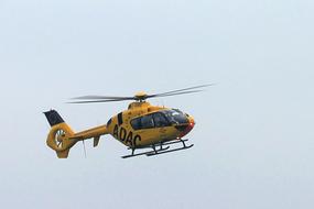 yellow helicopter in a blue sky