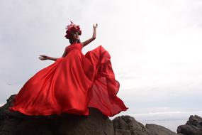 The girl has a red dress with a wreath