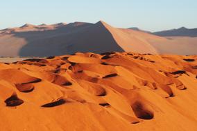 red sand with mountains on a background of clouds