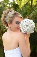 smiling Bride with white bouquet at face