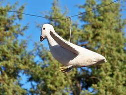 white bird figure in the trees