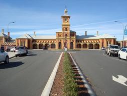 cars are parked along the road near a beautiful building
