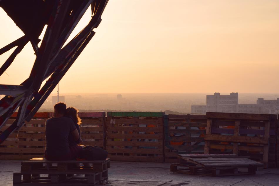 Couple hugging on roof in city at Sundown
