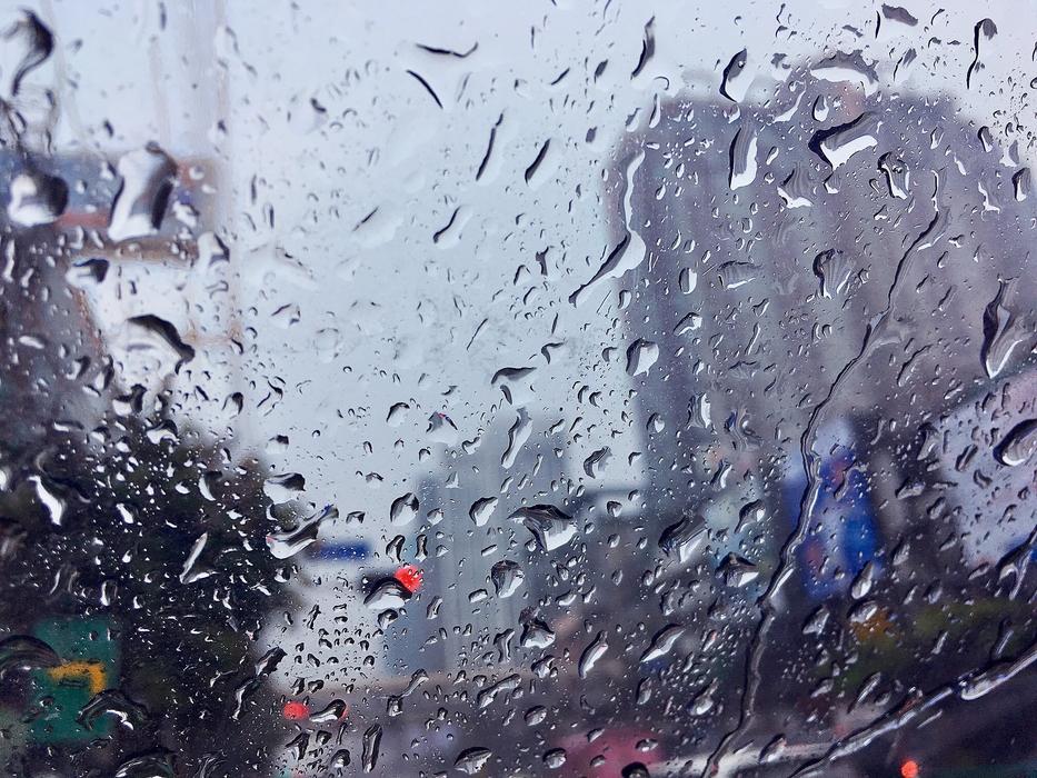 Beautiful view of the city, through the glass with rain drops