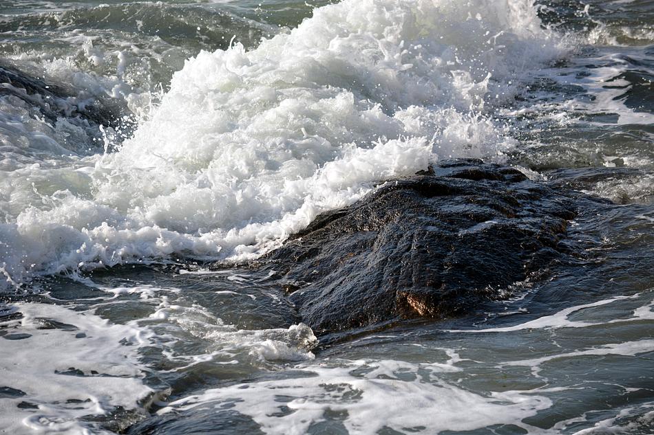 sea waves crash against a rock