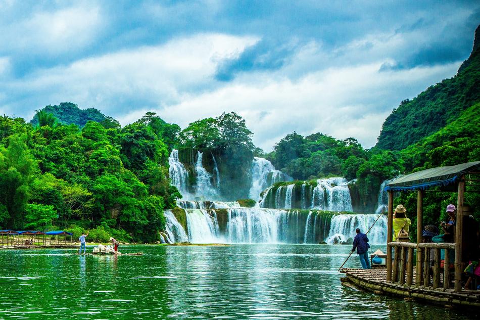 green trees with a waterfall at the man
