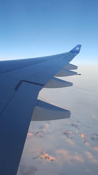 an airplane wing in the blue sky