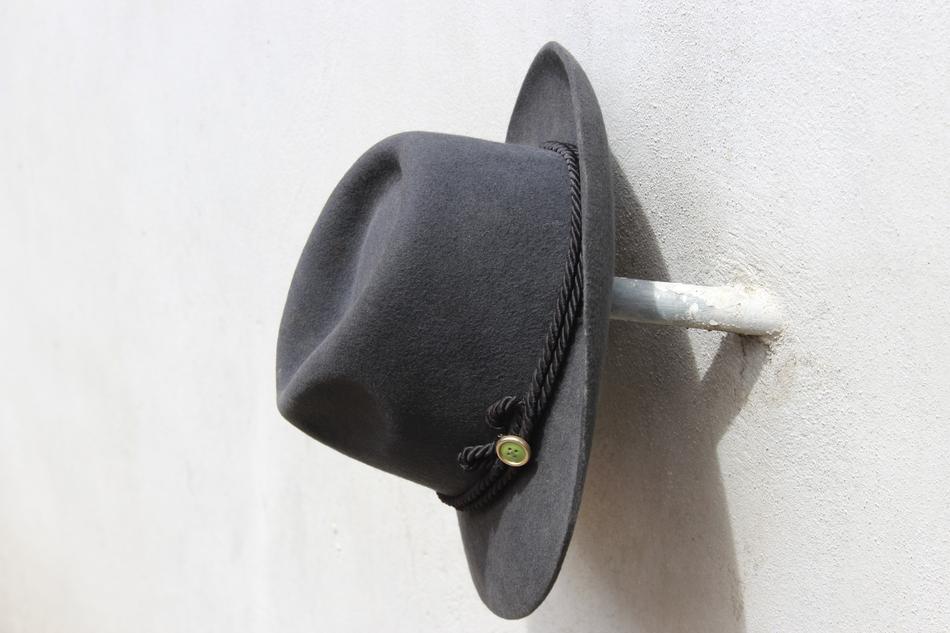 a black hat on a white wall
