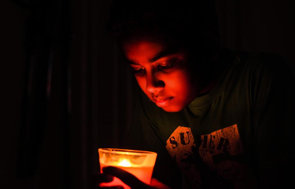 a baby by a candle in the dark