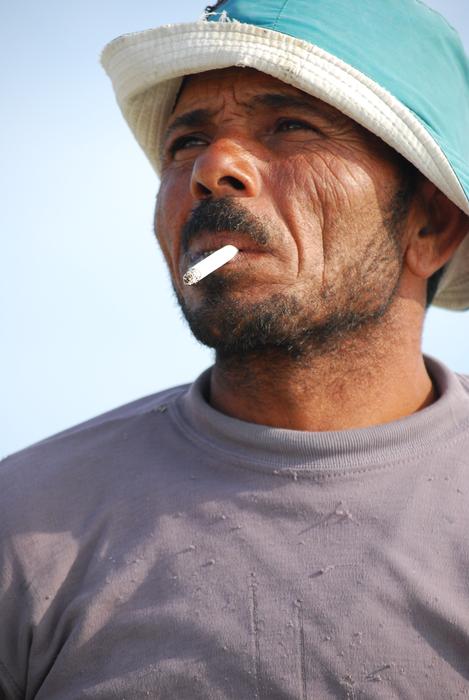 mature man in hat smoking Cigarette