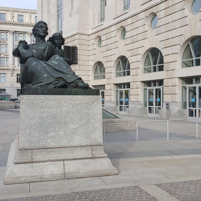 The sculpture is black on the square