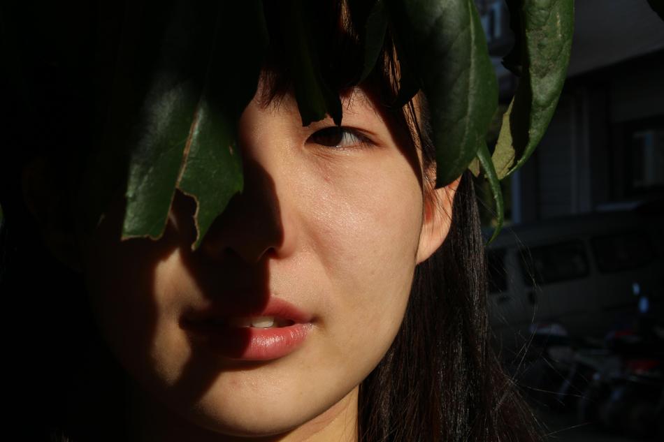 The girl hid behind the leaves