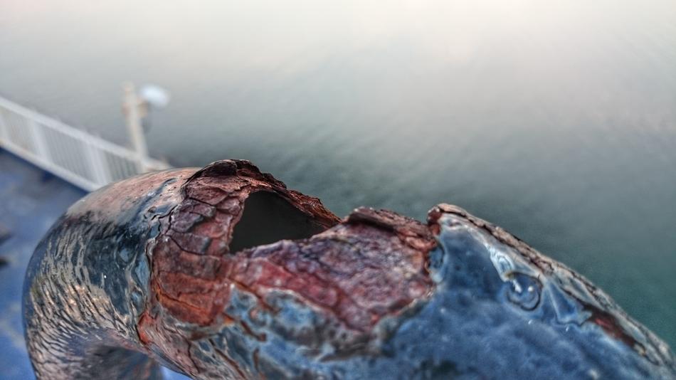 a rusty pipe by the water