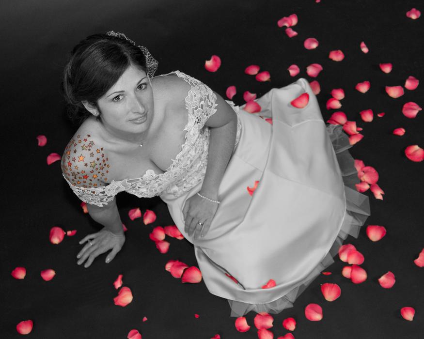 a girl in a white dress and rose petals