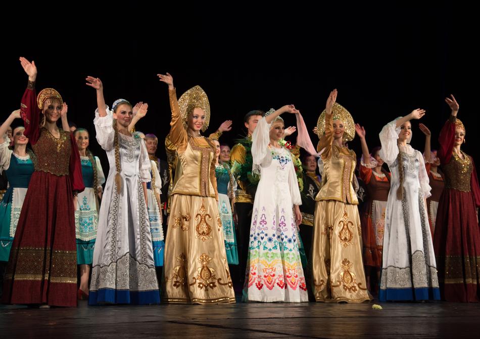 girls in dresses waving