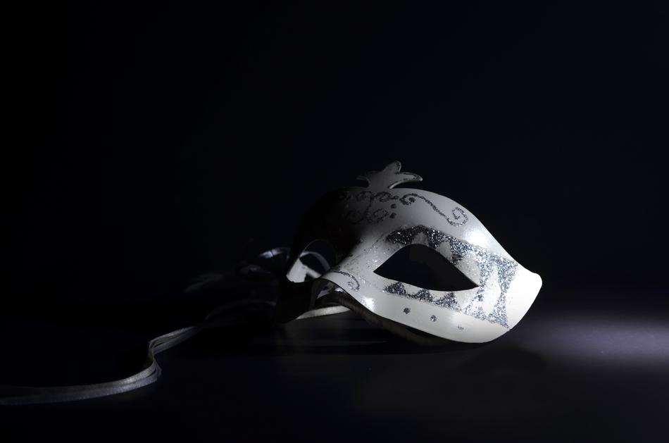the girl has a white mask in her hand on a black background