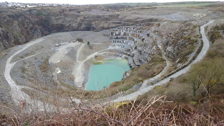 a quarry with a lake on the mountains