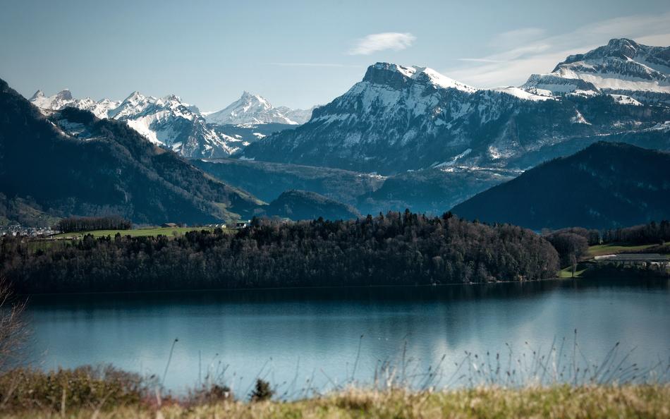 snowy mountains in the distance by the lake