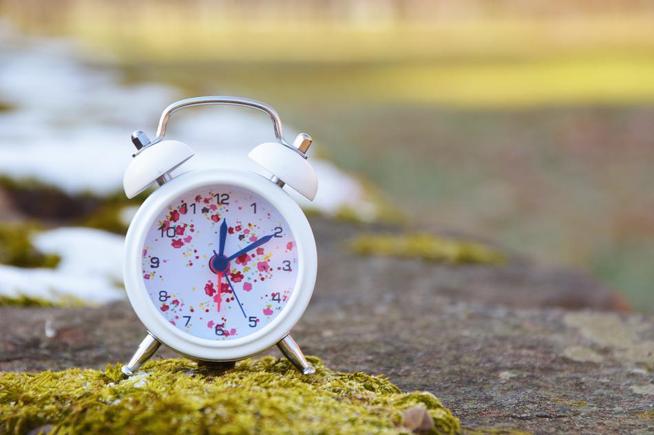 A white alarm clock with drops of paint