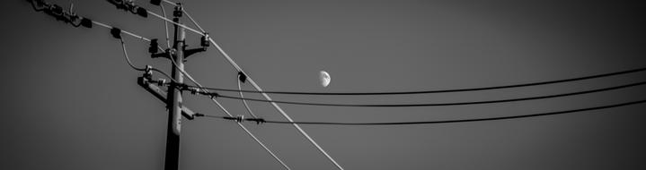 half moon above pillar with wires at Sky