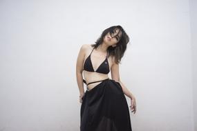 photo of a girl in a black bikini and black skirt
